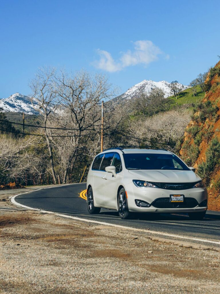 free photo of a chrysler pacifica minivan driving on a road in mountains